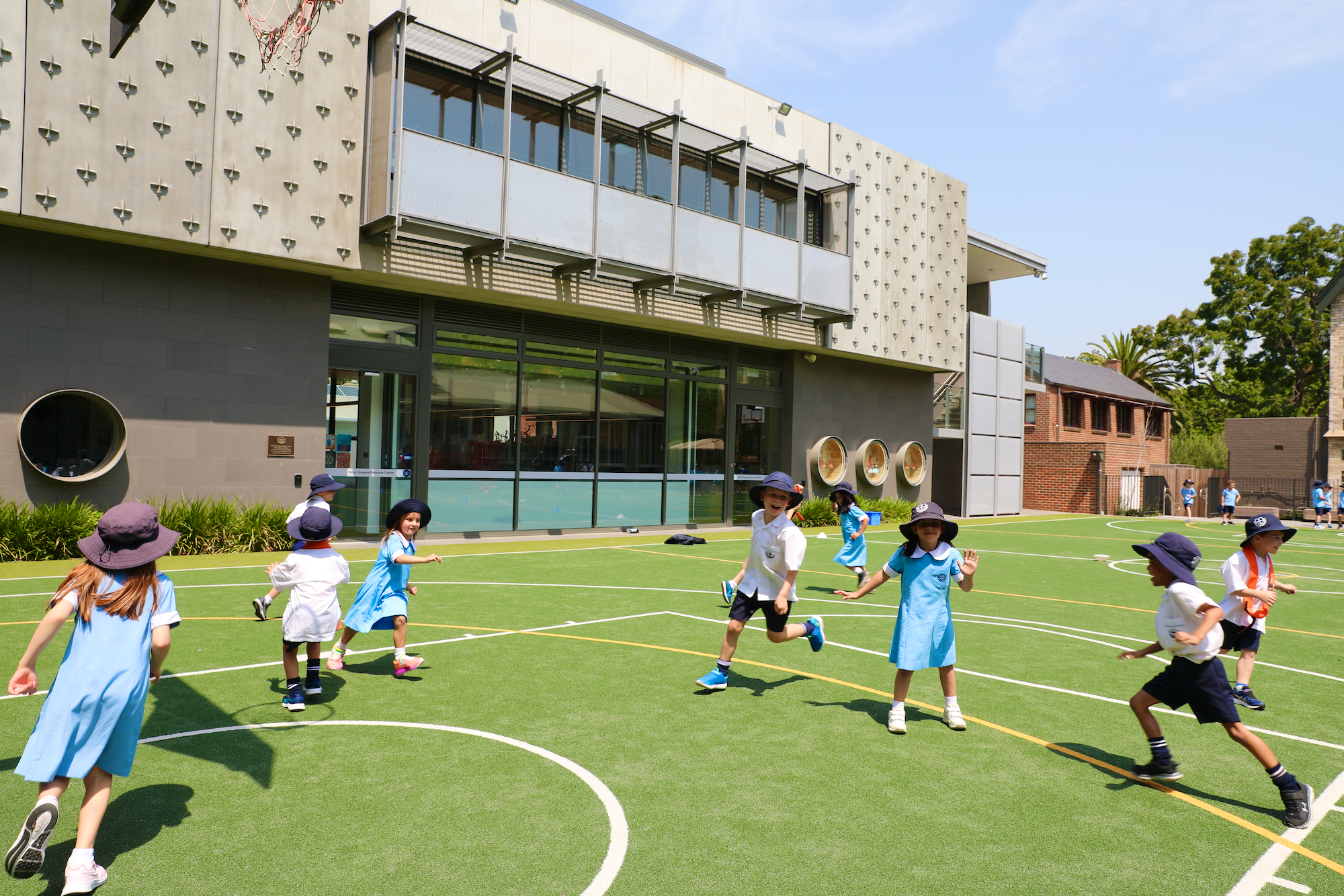 primary school kids in school uniforms playing on a quad court