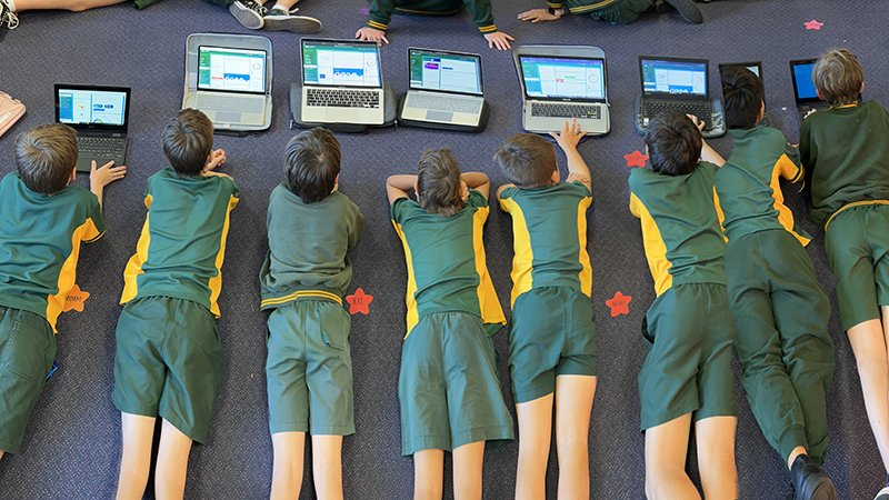 students lined up on the classroom mat using banqer on their laptop computers