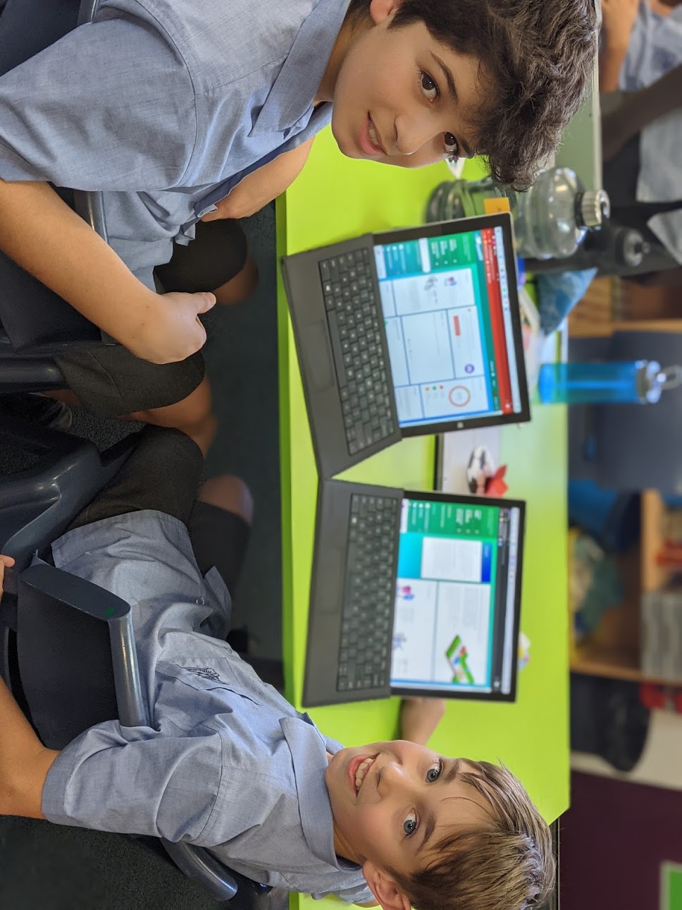 two primary school boys on their laptops in a classroom using banqer