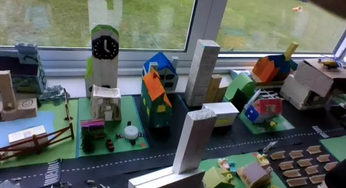 a primary school display of a town created from paper, cardboard and miscellaneous toys