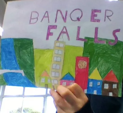 photo of a hand holding up a hand-drawn image of a town called banqer falls