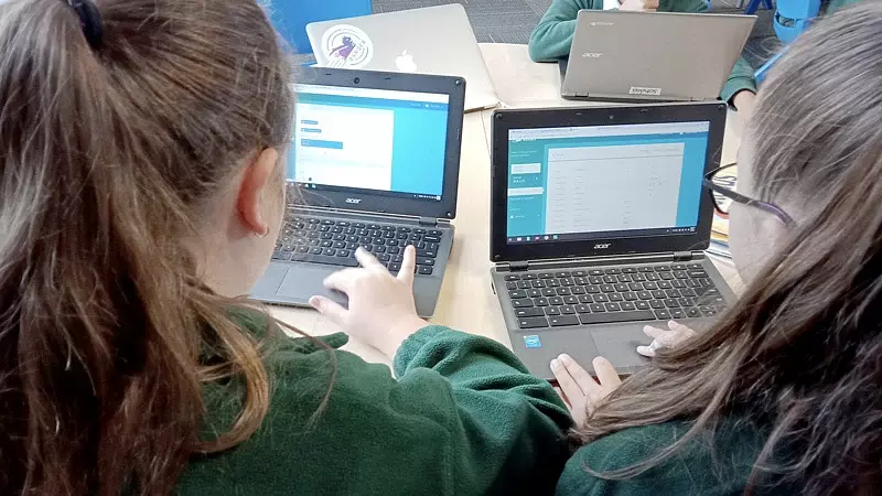 two students on their laptops using banqer